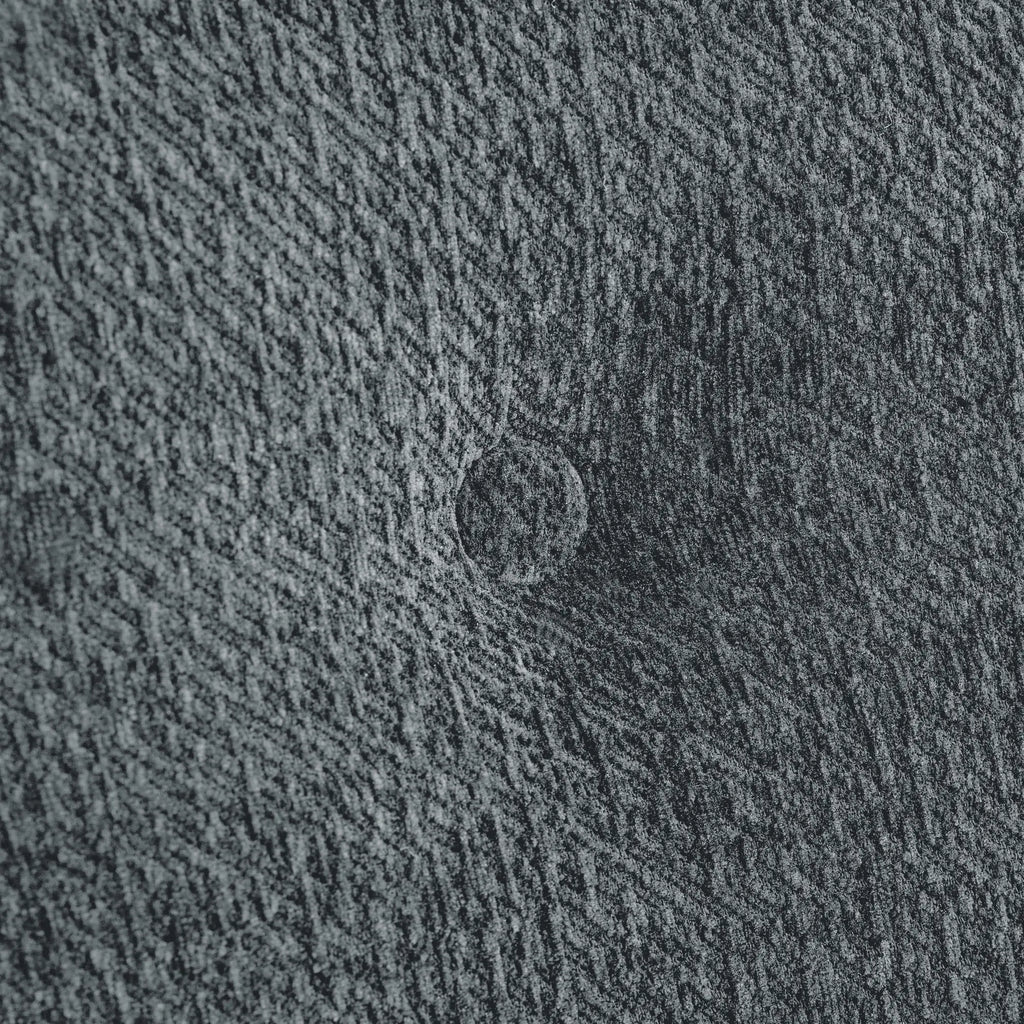 Macro close-up of the Korser grey fabric sofa, highlighting the detailed woven texture of the upholstery.
